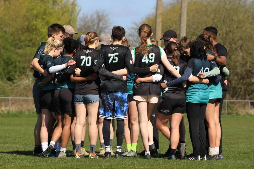 Flyght players in a team huddle between points at a tournament